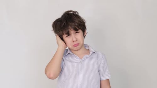 Boy Experiencing Ear Pain in Close-Up Studio Shot