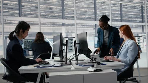 Women Working Together in Office to Examine Semiconductor Substrate