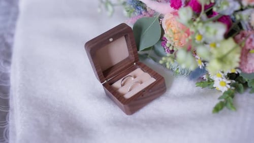Wedding Rings in Wooden Box with Flowers Bouquet