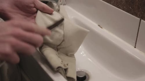 Close up of cloth being scraped with a knife