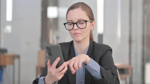 Young Woman Using Smartphone in Modern Office