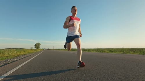 Young Adult Running on Country Road on Sunny Day