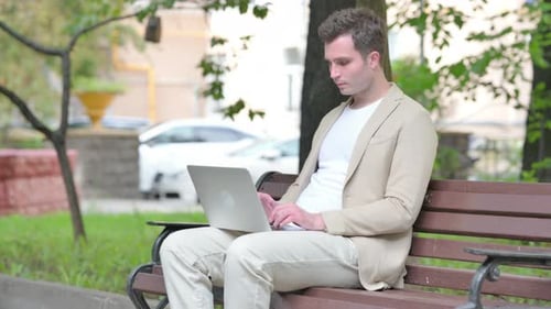 Young Adult Uses Laptop in the Park