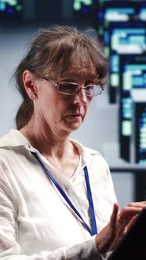 Woman With Glasses Uses Tablet in Office