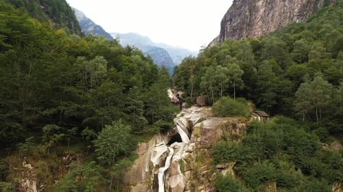 Aerial view of an incredible steep waterfall surrounded by the lush vegetation of the forest