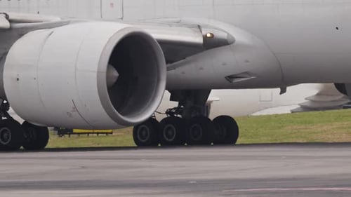 El motor y el tren de aterrizaje de un avión de pasajeros grandes rodando en la pista