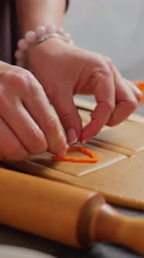 Woman Cutting Cookie Dough with Cutter in Kitchen
