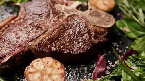 Grilled TBone Steak on Table Close Up Handheld Camera
