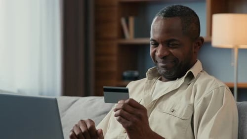 Man Uses Credit Card with Laptop at Home