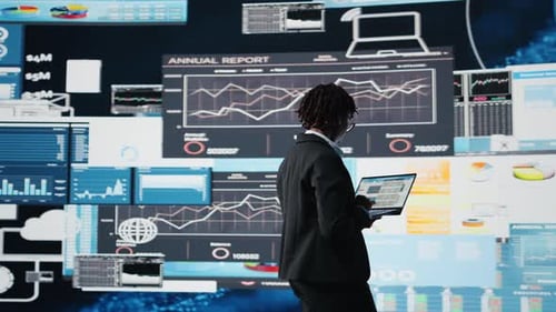 Woman Working with Laptop Surrounded by Data Screens