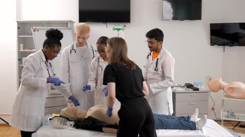 Instructor teaching first aid cardiopulmonary resuscitation course and use of defibrillator