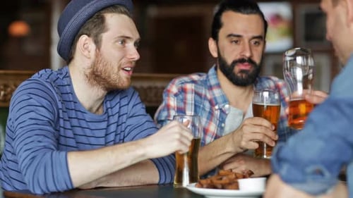 Friends at a bar cheersing with beer