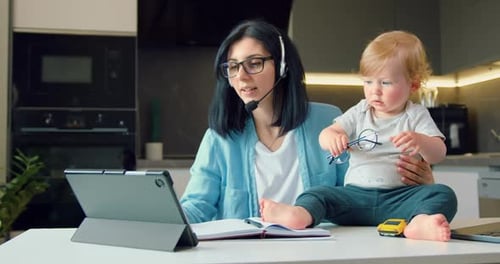 Woman Working at Home With Baby