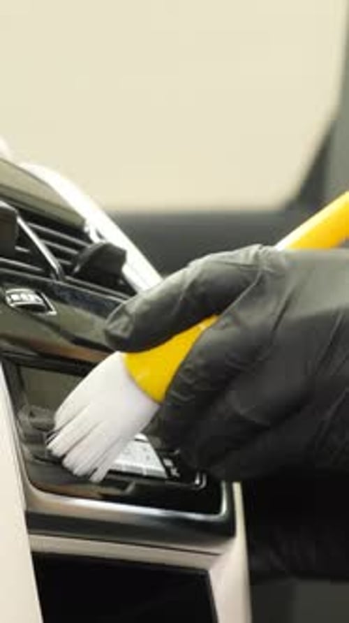 Closeup of Interior Cleaning in a Car A Worker Collects Dirty Water with a Vacuum Cleaner