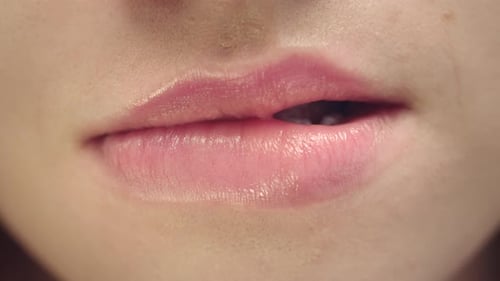 Sensual Woman Biting and Licking Plump Lips. Close Up Young Woman Face