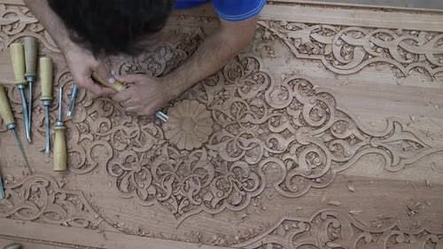 Artisan Carving Intricate Designs in Wood, Top Down View