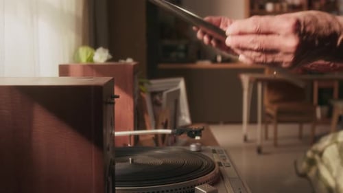 Senior Adult Playing Vinyl Record on Turntable