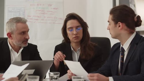 A Team of Businessmen is Studying Documents While Sitting in the Office Businessmen Study the