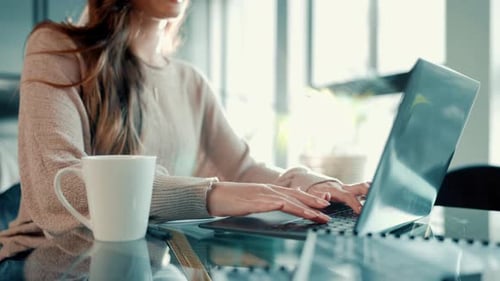 Hände, Laptop und Tippen mit Kaffee für die Telearbeit zu Hause zum Informieren, Recherchieren und Schreiben