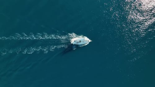 An aerial view of the sail yacht on the blue sea. Transparent clear water in the sea.