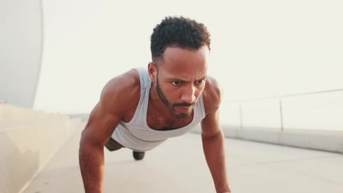 Close up, young athlete doing workout, push ups on the embankment