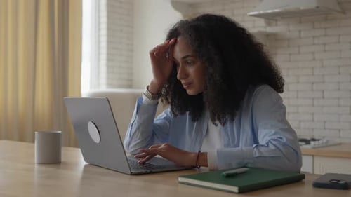 Woman Working Frustrated at Laptop in Kitchen