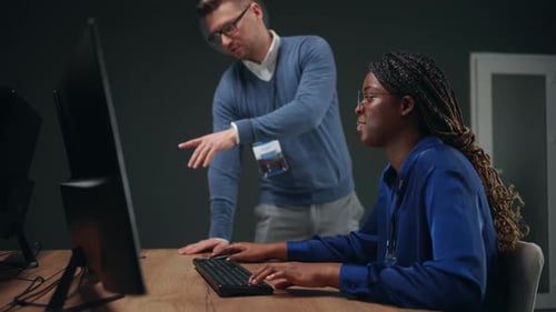 Schwarze 3D-Ingenieurin und männlicher Designer arbeiten zusammen im Büro eines internationalen Unternehmens