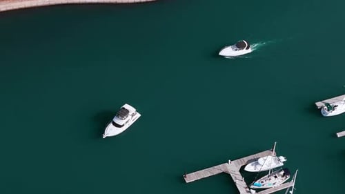 Aerial Slow Motion Shot of Boat in Waters Near Marina Panning Shot of Boat Swim and Raise Waves in