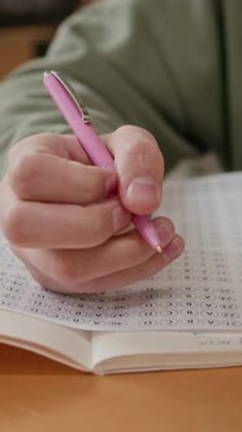 Teenager schreibt Antworten während des Tests im Klassenzimmer