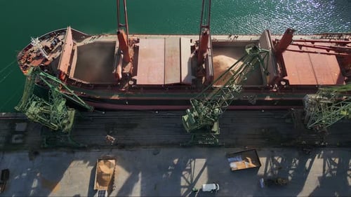 Aerial View of Big Cargo Ship Bulk Carrier is Loaded with Grain of Wheat in Port at Sunset