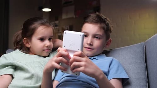 Children Playing Video Game Indoors at Home
