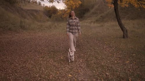 Woman Walking the Dog in the Park Forest