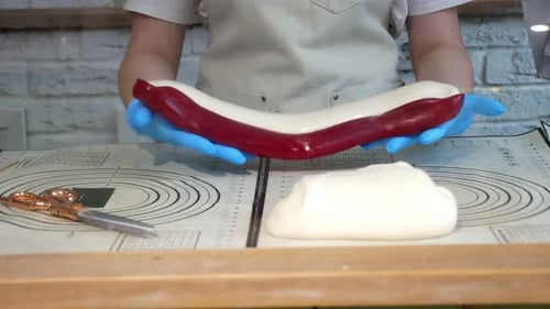 Pastry Chef Works with Soft Caramel in a Kitchenrolls Out Red and White Caramel