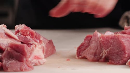 Raw Meat being Cut on Board