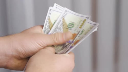 Close-up hands counting money.