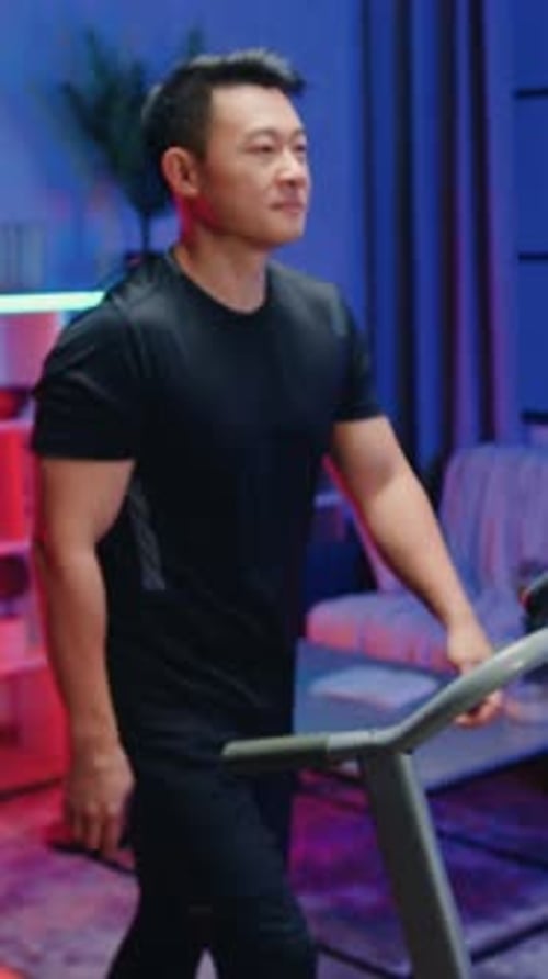 Man Smiles on Treadmill Exercising at Home