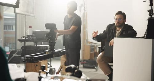 Bearded Man Directing Camera Crew in Studio