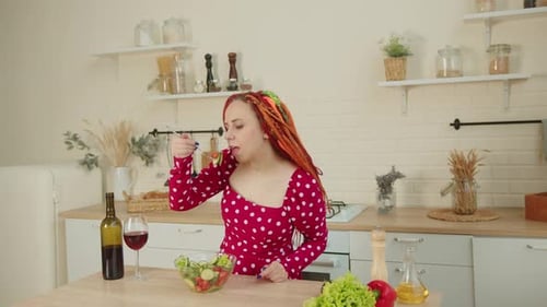 Young Woman Enjoys Salad in Bright Kitchen