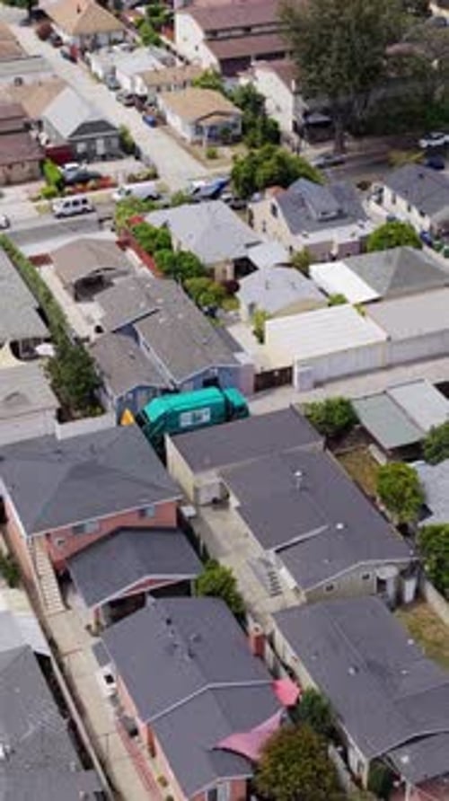 Aerial Top Down Inspection of a Low Income Neighborhood with Small Homes Trees Cars and Streets in
