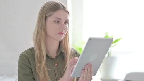 Woman Interacts with Tablet Indoors