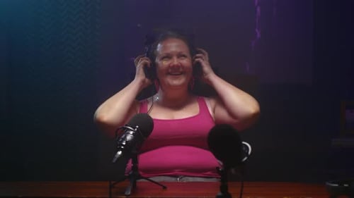 Woman Smiling While Recording a Podcast