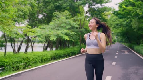 Asian beautiful sportswoman doing running exercise alone in the garden.