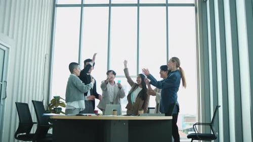 Enthusiastic Business Team Joining Hands in Modern Office