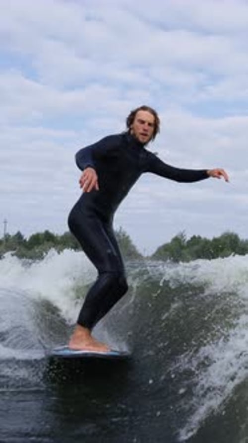 Dynamic Surfing Action A Skilled Rider Balances on a Wave During a Perfect Ride Showcasing Surfing