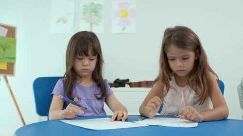 Two Young Girls Drawing at a Table