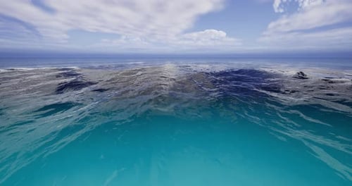 Calm Ocean Waters Reflect Blue Sky with Distant Waves and Clouds