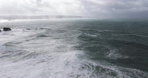Powerful Atlantic dark ocean waves rising in famous iconic Nazaré, nature aerial drone shot