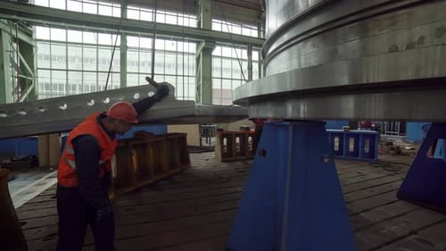 A Worker is Thoroughly Inspecting a Large Piece of Industrial Machinery Within a Factory Stock Clip