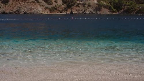 Wellen am Strand mit türkisfarbenem Wasser, Nahaufnahme, weißem Sand, Reisekonzept, Urlaub am Strand