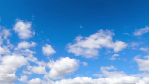 Fluffy soft white clouds moving by the azure skies. Cloudscape formation in the atmosphere.
